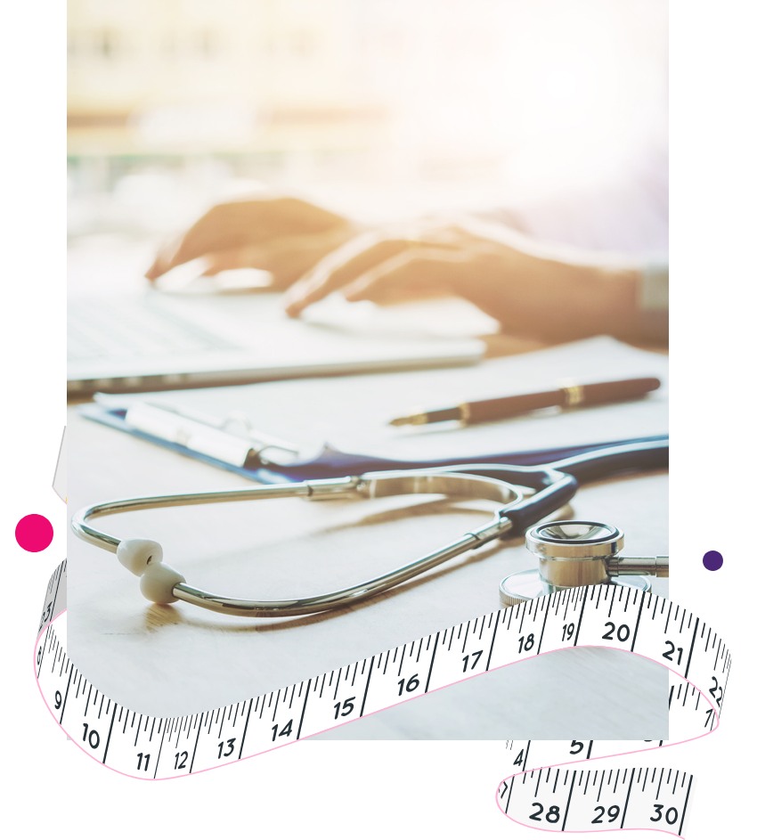 Women hands while working on a laptop with a stethoscope on the side of the table