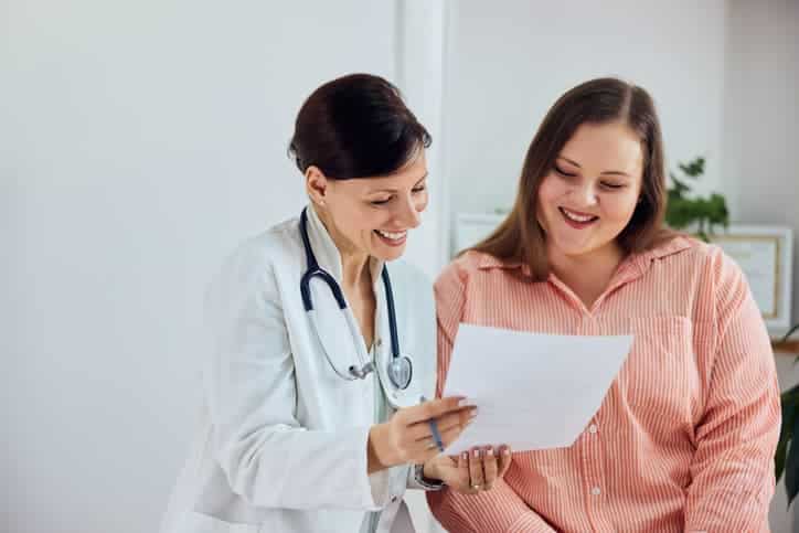 A doctor is showing some reports to a healthy patient